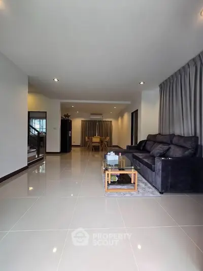 Spacious modern living room with sleek tile flooring and cozy seating area.