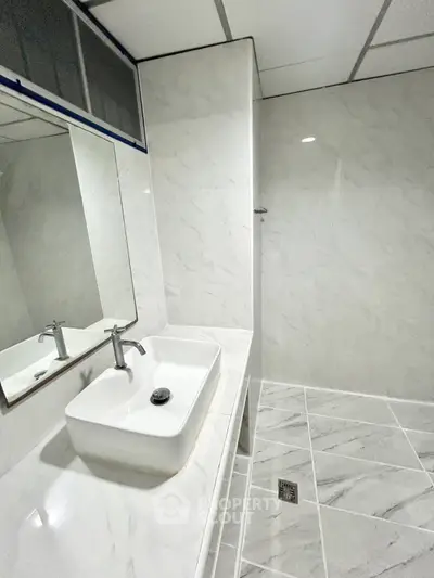 Modern bathroom with sleek white marble tiles and stylish sink