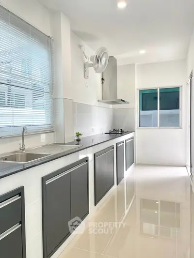 Modern kitchen with sleek cabinetry and gas stove in bright, airy space.