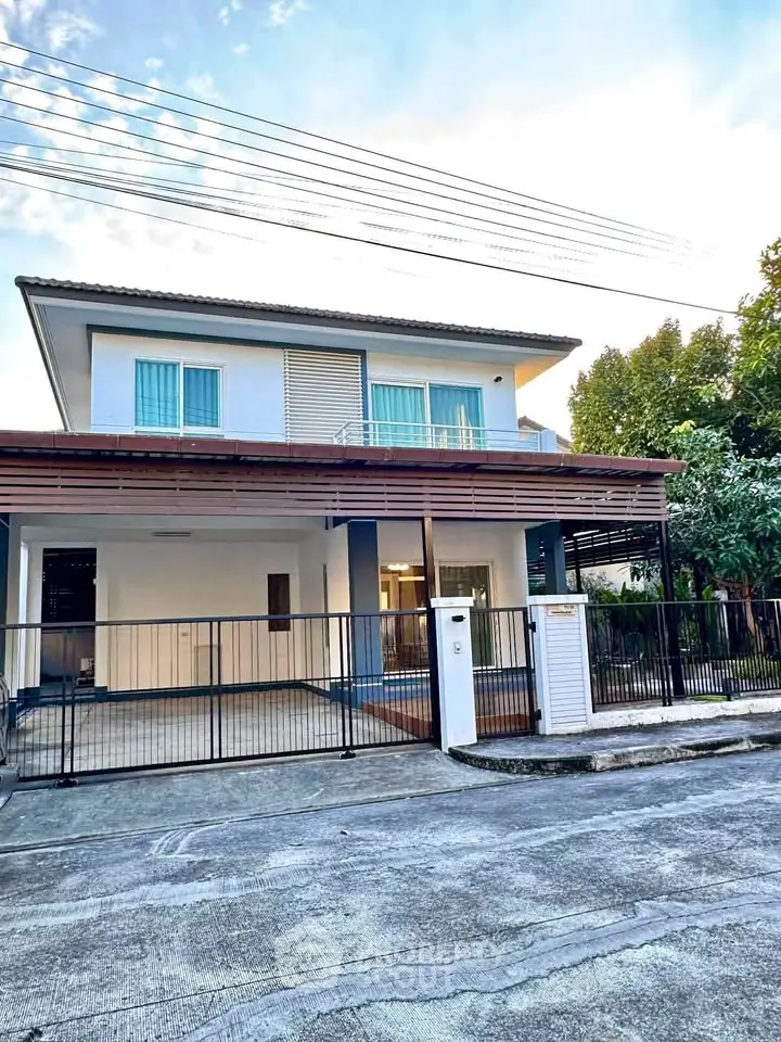 Modern two-story house with spacious driveway and gated entrance