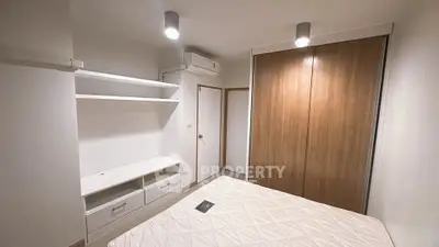 Modern bedroom with built-in storage and air conditioning in a cozy apartment.
