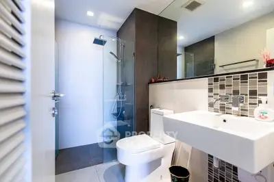 Modern bathroom with sleek design, featuring glass shower and stylish fixtures.