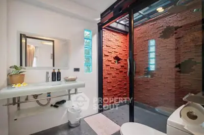 Luxurious modern bathroom with glass shower and stylish brick wall design