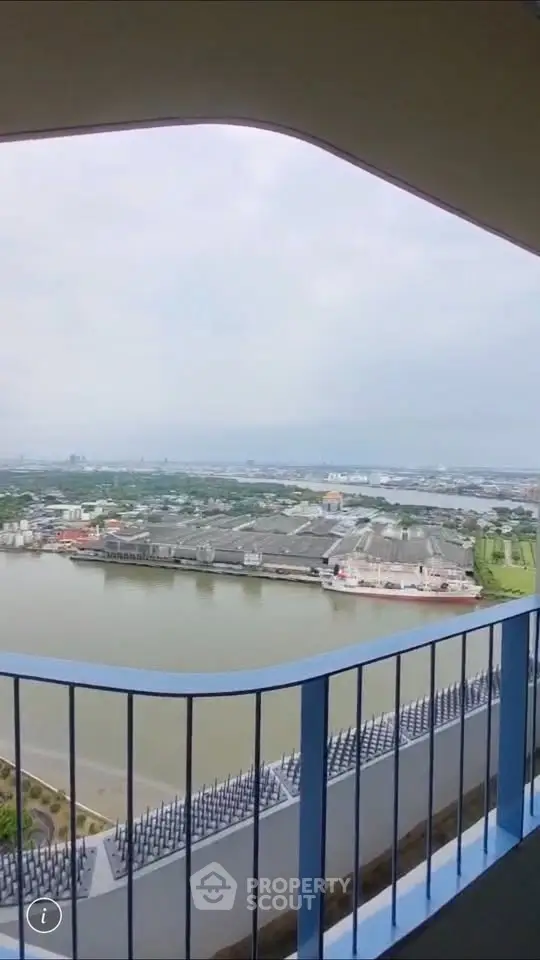 Stunning high-rise balcony view overlooking a serene river and cityscape, perfect for urban living.