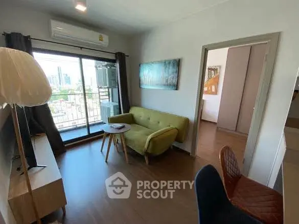 Modern living room with city view, stylish furniture, and large windows in urban apartment.