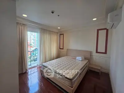 Spacious bedroom with balcony access and natural light in modern apartment.