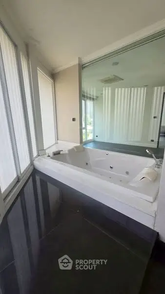 Luxurious bathroom with a modern bathtub and large mirror, offering a serene and elegant atmosphere.