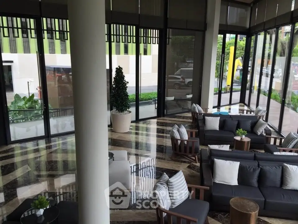 Luxurious modern lobby with elegant seating and floor-to-ceiling windows offering a lush garden view.