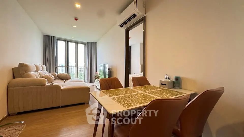 Spacious living room with modern decor and large windows offering a stunning view, perfect for relaxation.