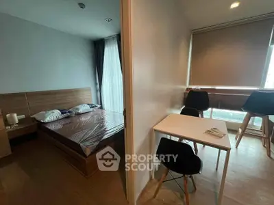 Modern apartment with cozy bedroom and dining area, featuring wooden flooring and natural light.