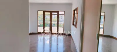 Spacious empty room with large windows and balcony access, perfect for natural light lovers.