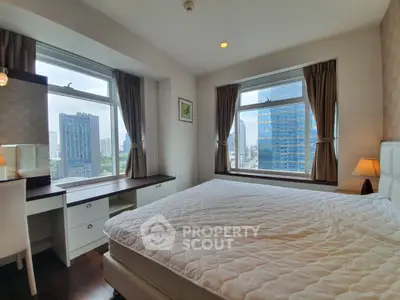 Spacious bedroom with city view and elegant furnishings in a modern apartment.