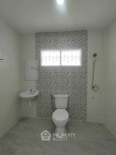 Modern bathroom with stylish tile accent wall and sleek fixtures.