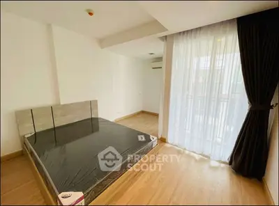 Spacious bedroom with large window and modern wooden flooring