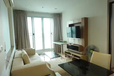 Modern living room with large windows and stylish furniture in a bright apartment.