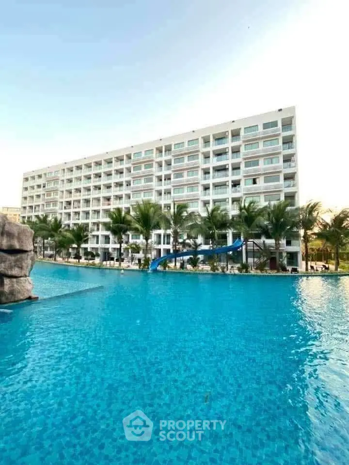 Luxurious beachfront condominium with stunning pool and palm trees, perfect for resort-style living.