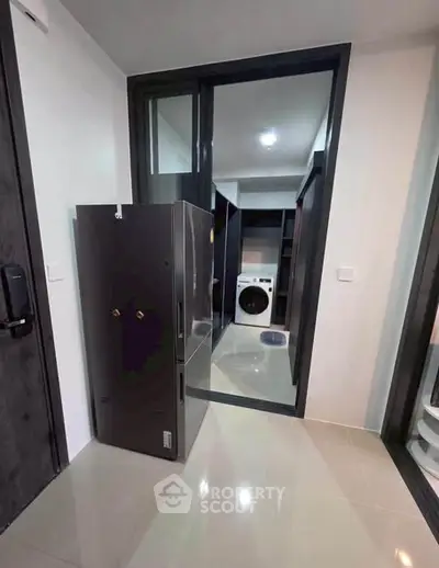 Modern laundry room with sleek appliances and glossy flooring