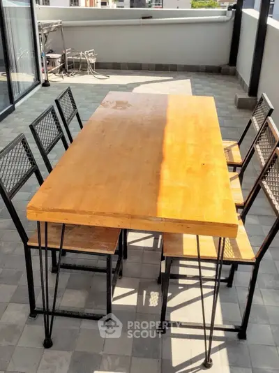 Spacious balcony with modern outdoor dining set, perfect for entertaining and enjoying city views.