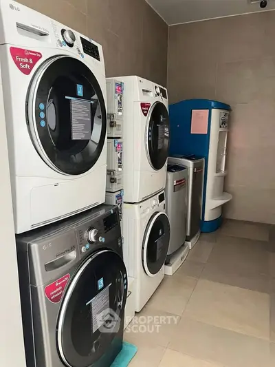 Modern laundry room with multiple washing machines and dryers in a sleek design.