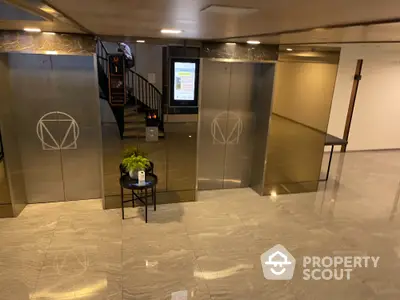 Modern building entrance with sleek elevator doors and marble flooring