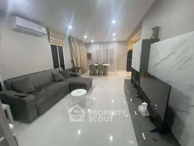 Modern living room with sleek furniture and ambient lighting, perfect for relaxation and entertainment.