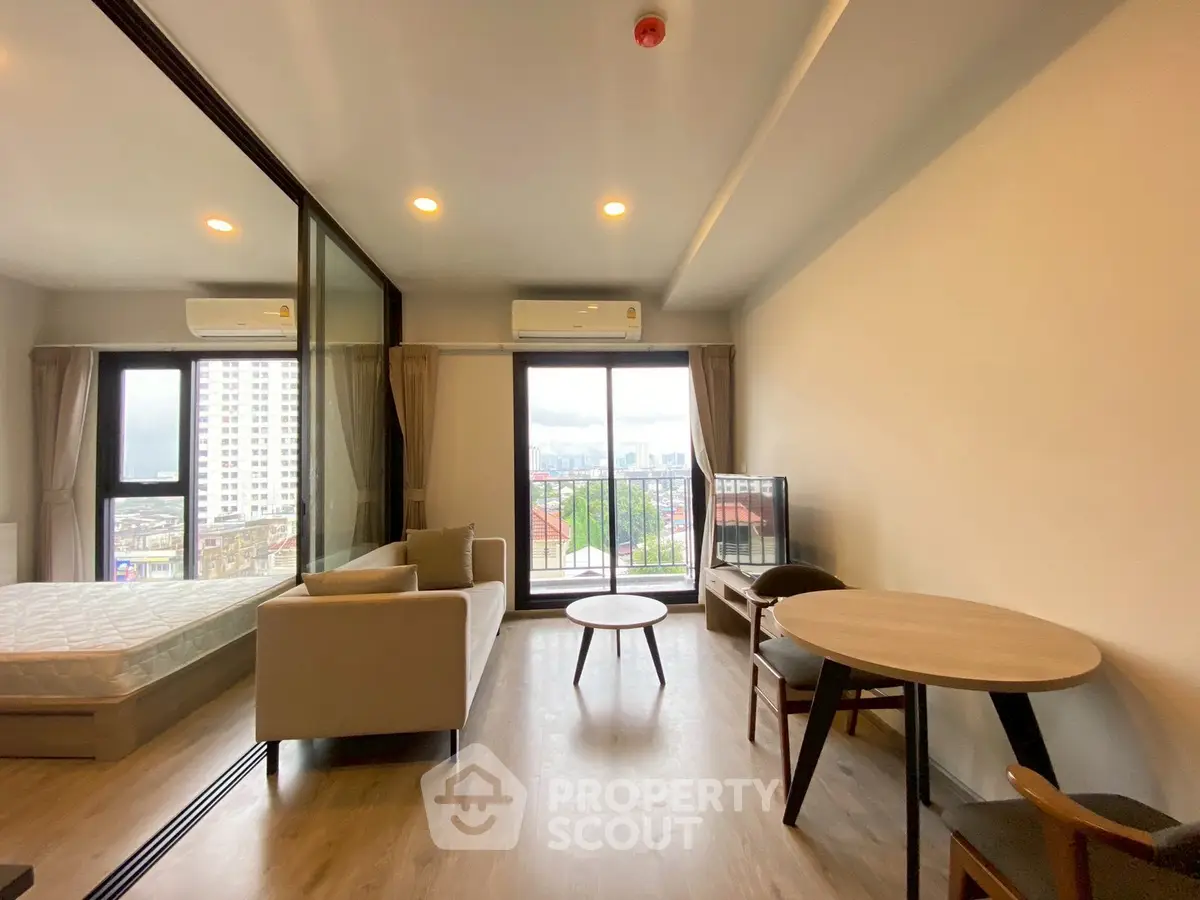 Modern living room with city view, cozy furniture, and natural light