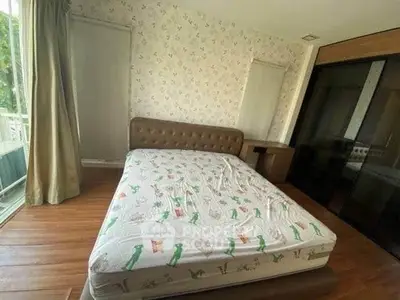 Cozy bedroom with large window and stylish wallpaper, perfect for relaxation.