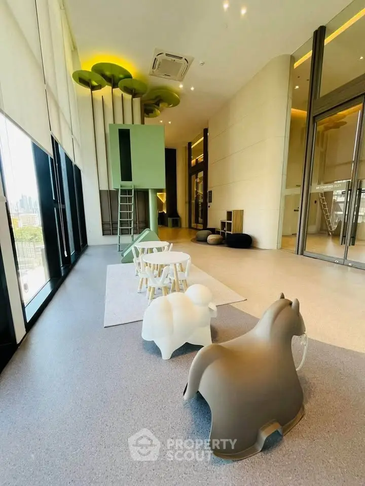 Modern high-ceiling living space with playful decor and large windows.