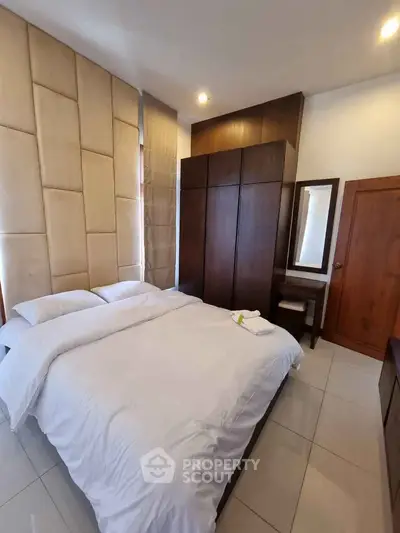 Modern bedroom with stylish headboard and wooden furniture