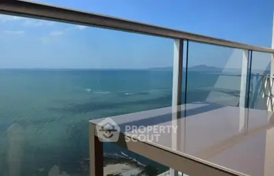 Stunning ocean view from a modern balcony with glass railing, perfect for relaxation and enjoying the scenery.