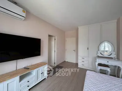 Modern bedroom with TV, air conditioning, and stylish furniture