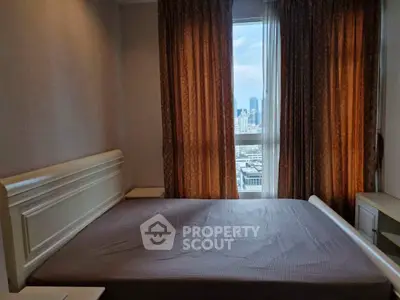 Cozy bedroom with city view, featuring elegant curtains and a comfortable bed, perfect for urban living.