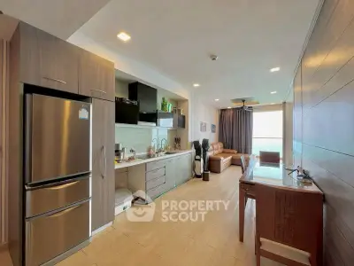 Modern open-layout kitchen and living area with sleek appliances and cozy seating.