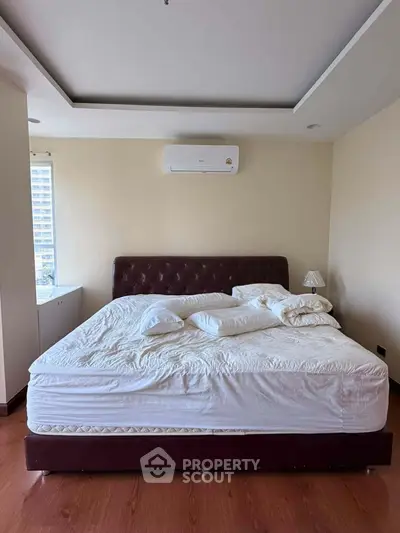 Spacious bedroom with large bed and modern air conditioning unit, perfect for comfort and relaxation.