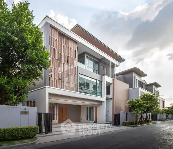 Modern luxury residential building with sleek design and spacious driveway in serene neighborhood.