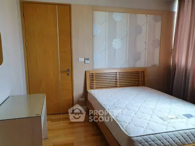 Modern bedroom with wooden accents and floral wallpaper, featuring a comfortable mattress and natural light.