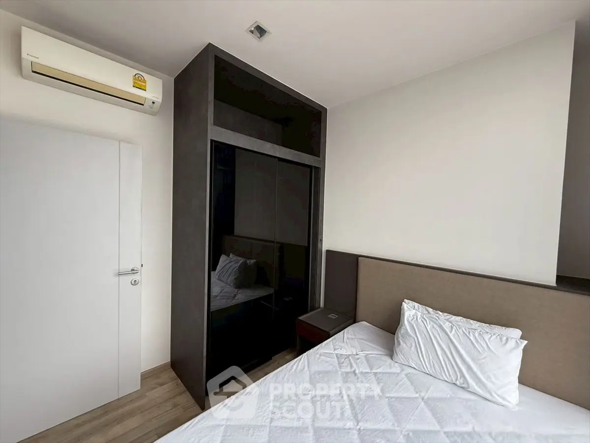 Modern bedroom with sleek wardrobe and air conditioning unit