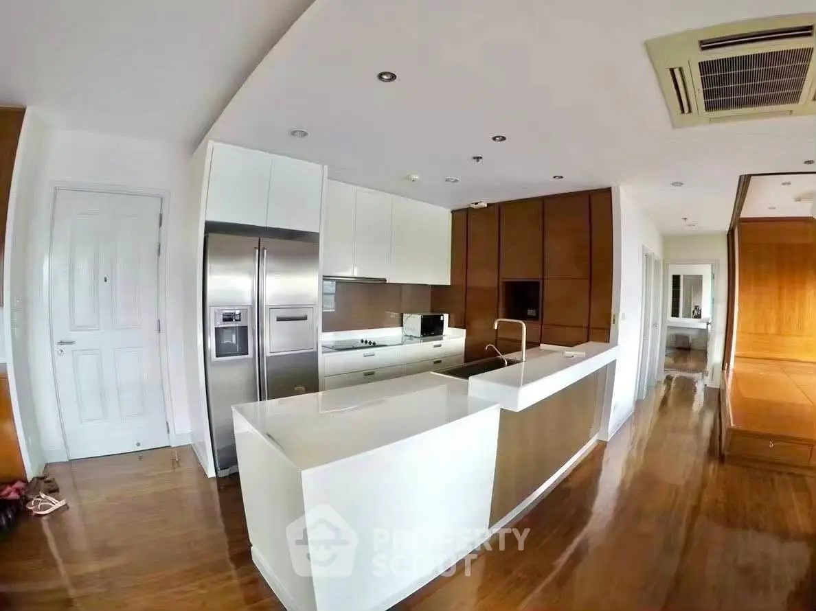Modern kitchen with sleek design, featuring stainless steel appliances and wooden accents.