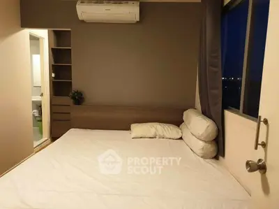 Cozy bedroom with air conditioning and modern decor, featuring a comfortable bed and ample natural light.