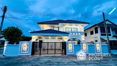 Stunning two-story modern house with elegant lighting and spacious driveway.