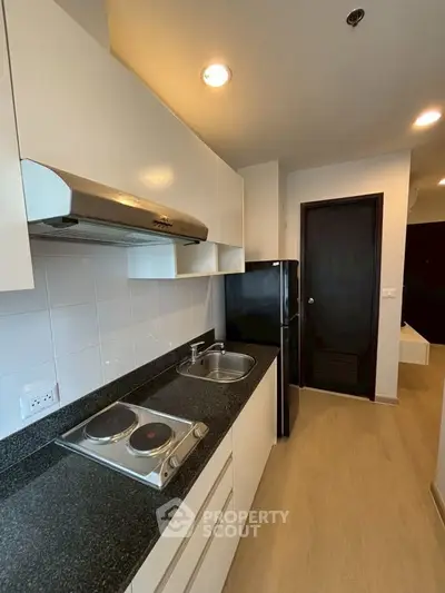 Modern kitchen with sleek countertops and electric stove in a cozy apartment