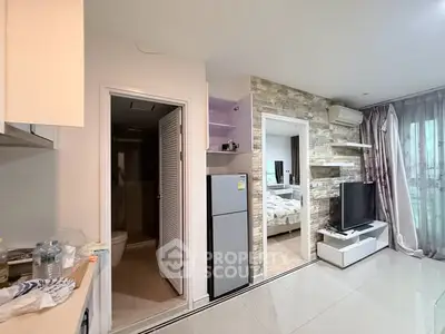 Modern apartment interior with open layout, featuring a cozy living room and adjacent kitchen area.