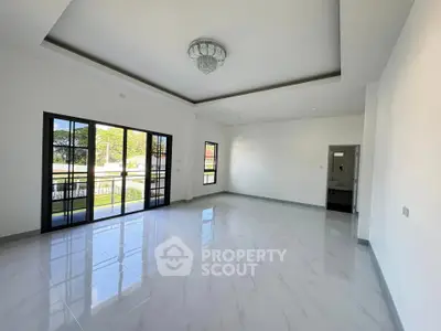 Spacious modern living room with large windows and elegant chandelier