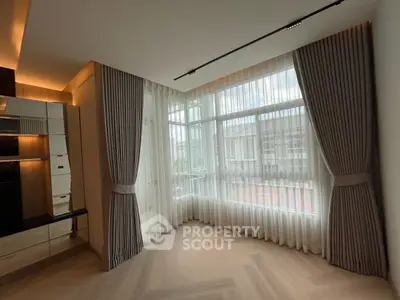 Elegant corner unit with large windows and stylish curtains in a modern apartment.