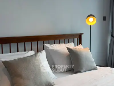 Cozy bedroom with elegant wooden headboard and stylish floor lamp