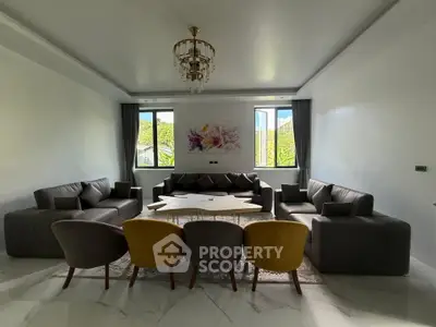 Luxurious living room with elegant chandelier and modern furniture, perfect for relaxation and entertainment.