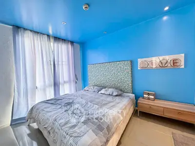 Bright and modern bedroom with blue accents and large window for natural light.