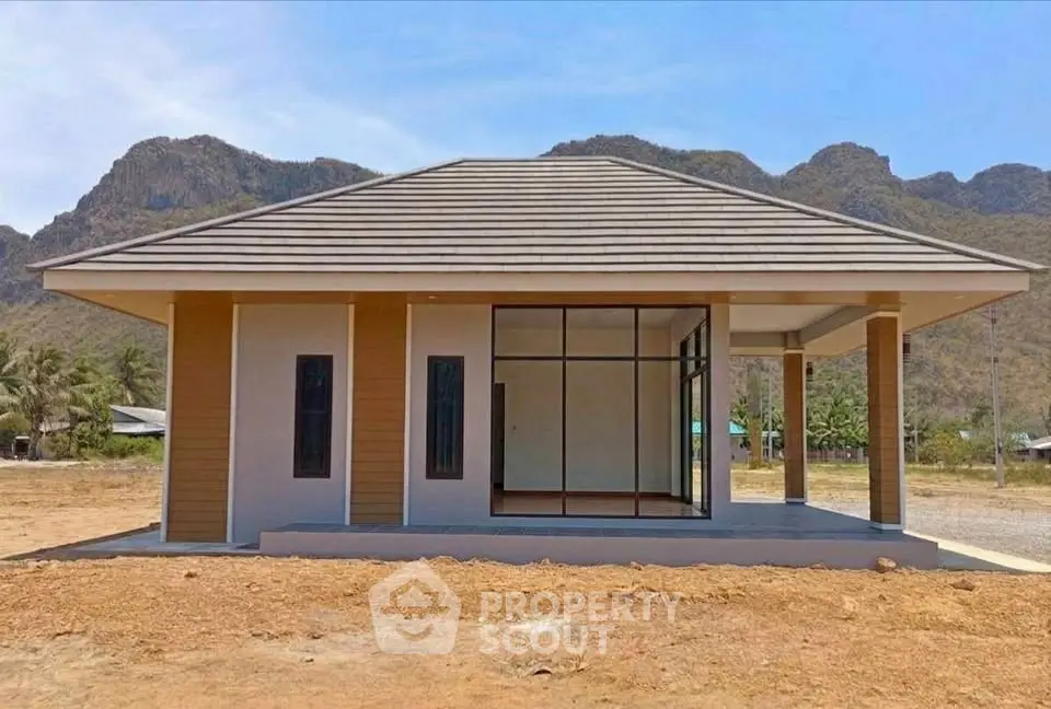 Charming single-story house with modern design set against scenic mountain backdrop.