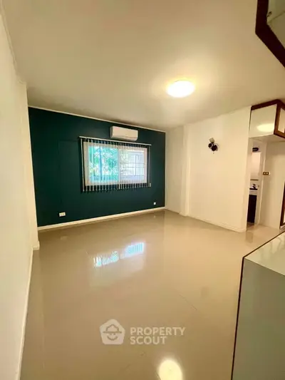 Spacious living room with modern design and large window for natural light.