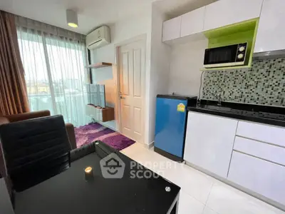 Modern studio apartment with compact kitchen and cozy living area, featuring a vibrant purple rug and natural light.